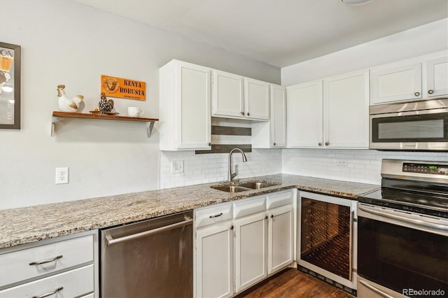 kitchen with stainless steel appliances, wine cooler, a sink, and white cabinetry