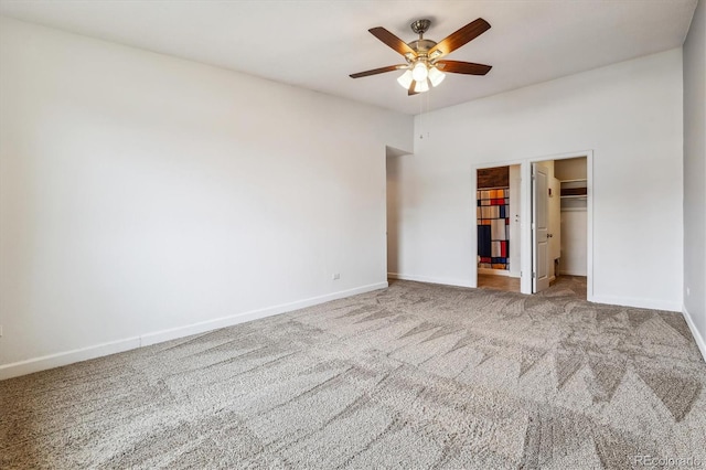 unfurnished bedroom featuring carpet flooring, baseboards, a spacious closet, and a closet