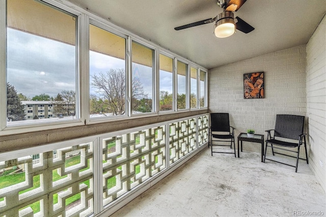 sunroom / solarium featuring lofted ceiling, healthy amount of natural light, and ceiling fan