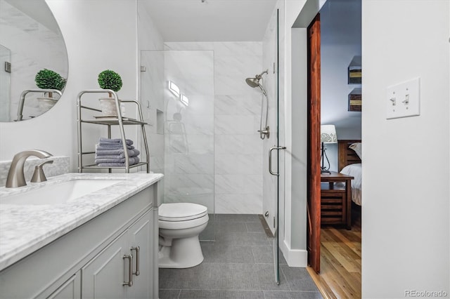 bathroom featuring an enclosed shower, tile patterned flooring, vanity, tile walls, and toilet