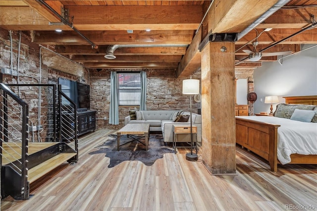 bedroom featuring hardwood / wood-style floors and beam ceiling