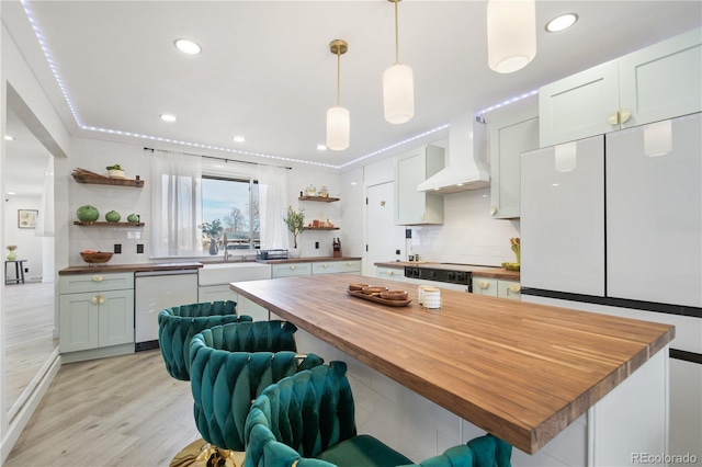 kitchen with white appliances, wood counters, decorative light fixtures, custom exhaust hood, and sink