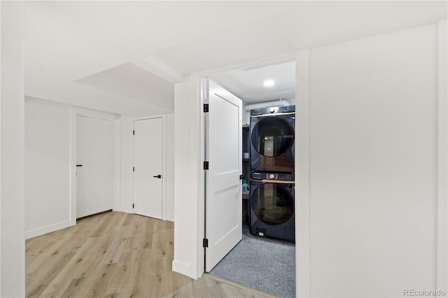 laundry area featuring light wood-type flooring and stacked washer / drying machine