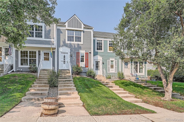 townhome / multi-family property featuring a front lawn