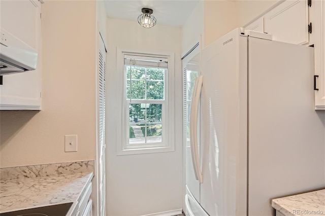 kitchen with pendant lighting, range, white cabinetry, exhaust hood, and white fridge