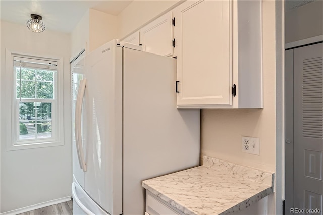 kitchen with white refrigerator, light hardwood / wood-style flooring, and white cabinets