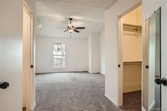 carpeted spare room with ceiling fan and a textured ceiling