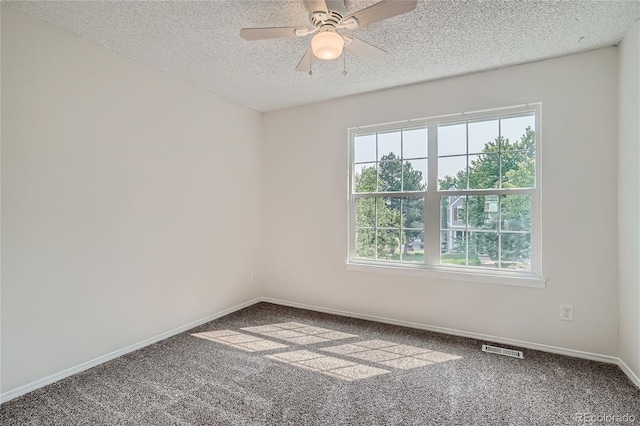 carpeted empty room with ceiling fan and a textured ceiling