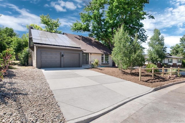 6097 S Jackson St, Centennial, CO 80121 - view of front of house with an attached garage, driveway, solar panels, and brick siding