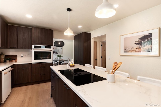 6097 S Jackson St, Centennial, CO 80121 - kitchen featuring white appliances, light wood-style floors, dark brown cabinets, pendant lighting, and light stone counters
