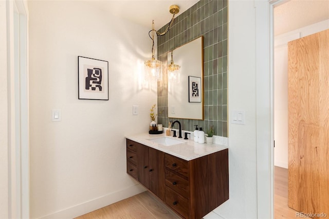 6097 S Jackson St, Centennial, CO 80121 - bathroom with vanity, wood finished floors, and decorative backsplash