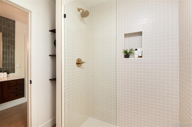 6097 S Jackson St, Centennial, CO 80121 - full bathroom with a tile shower, vanity, and wood finished floors