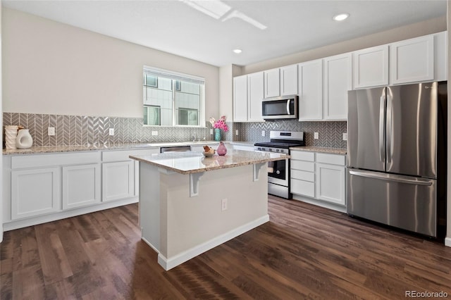 1330 Independence St Unit 2, Lakewood, CO 80215 - kitchen with appliances with stainless steel finishes, white cabinetry, a kitchen island, decorative backsplash, and recessed lighting