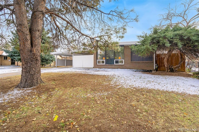 view of front facade featuring a front lawn and a carport