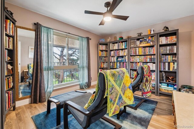 6495 E Happy Canyon Rd Unit 163, Denver, CO 80237 - office area with light wood-type flooring, ceiling fan, and wall of books