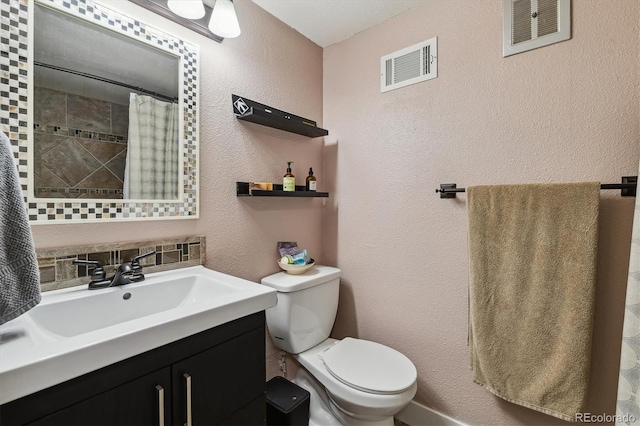 6495 E Happy Canyon Rd Unit 163, Denver, CO 80237 - full bathroom with a textured wall, toilet, vanity, and a shower with curtain