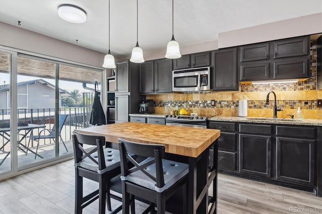 6495 E Happy Canyon Rd Unit 163, Denver, CO 80237 - kitchen featuring appliances with stainless steel finishes, a sink, dark cabinets, and butcher block counters