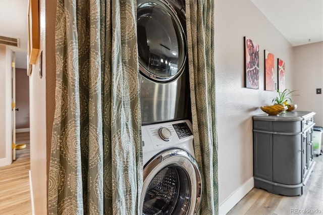 6495 E Happy Canyon Rd Unit 163, Denver, CO 80237 - laundry room with stacked washer / dryer, wood finished floors, and baseboards