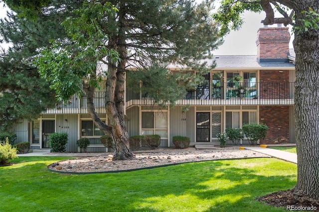 6495 E Happy Canyon Rd Unit 163, Denver, CO 80237 - rear view of house featuring a chimney, a yard, and a balcony