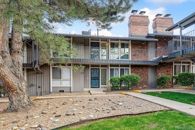 6495 E Happy Canyon Rd Unit 163, Denver, CO 80237 - rear view of house with a balcony, a chimney, and brick siding