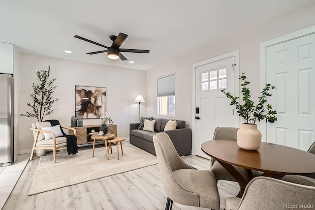 dining space with ceiling fan and light hardwood / wood-style flooring