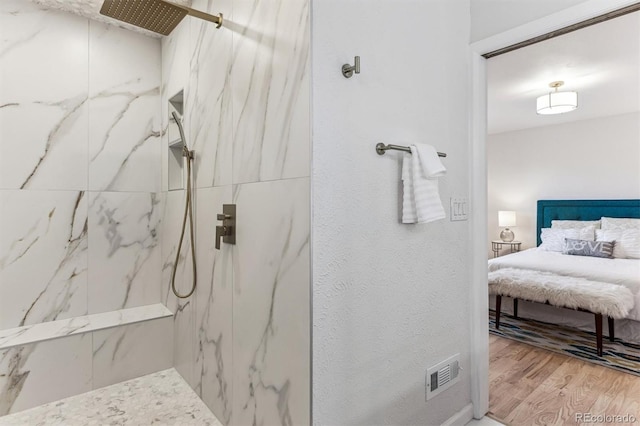 bathroom featuring a marble finish shower, visible vents, connected bathroom, and wood finished floors