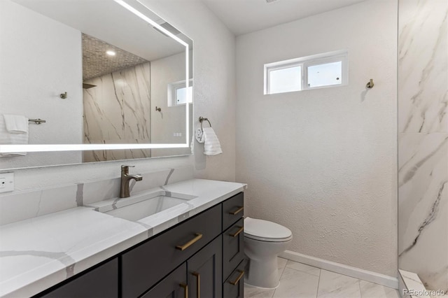 full bathroom with toilet, marble finish floor, vanity, and a textured wall