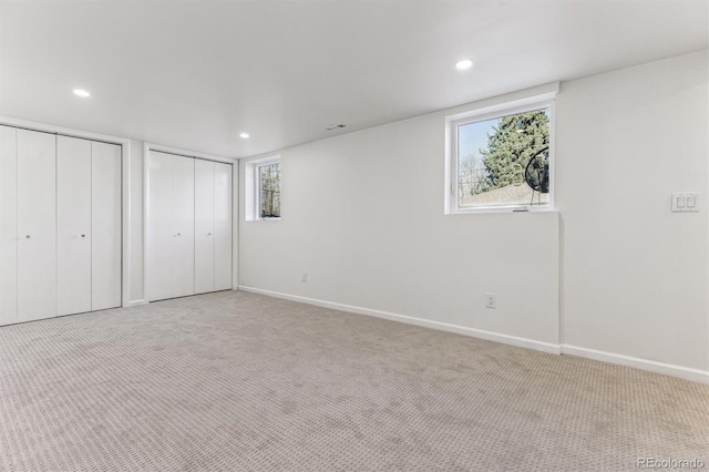 unfurnished bedroom with recessed lighting, baseboards, carpet, and multiple closets