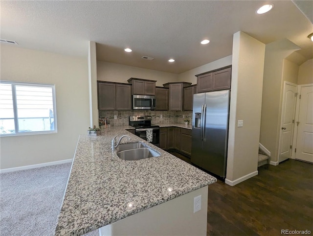 kitchen with light stone countertops, sink, dark wood-type flooring, tasteful backsplash, and appliances with stainless steel finishes