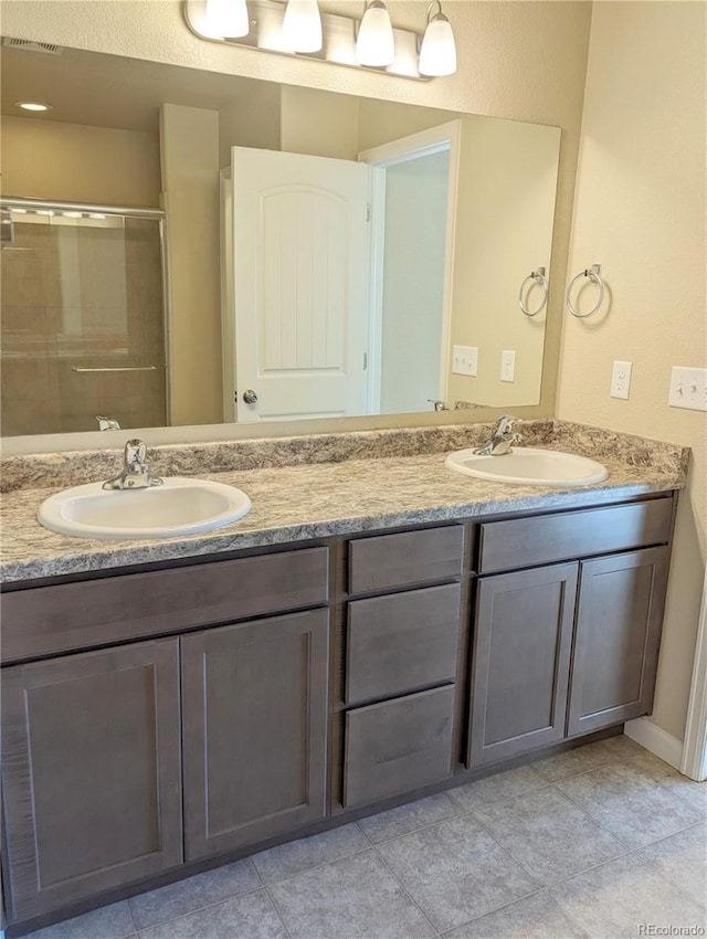 bathroom featuring tile patterned floors, vanity, and an enclosed shower