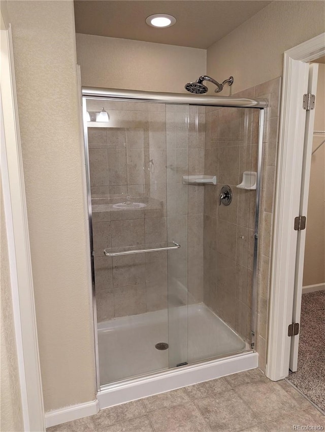 bathroom featuring tile patterned flooring and a shower with door