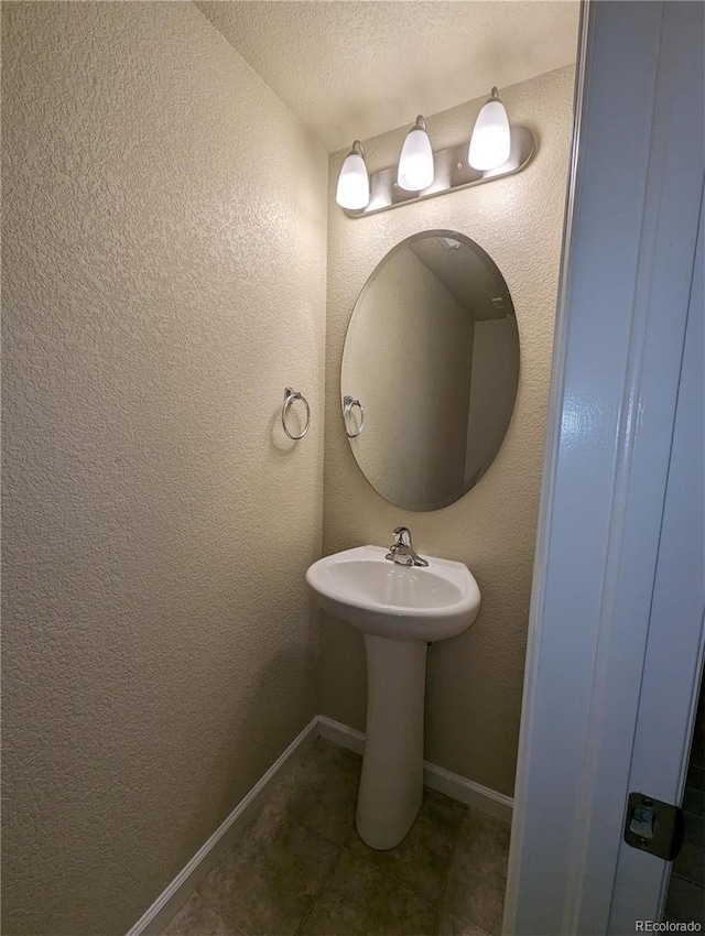 bathroom featuring a textured ceiling and tile patterned floors