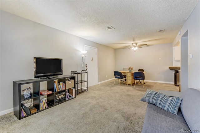 living room with carpet flooring, ceiling fan, and a textured ceiling