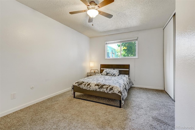 carpeted bedroom with ceiling fan and a textured ceiling