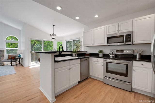 8884 Miners St, Highlands Ranch, CO 80126 - kitchen with appliances with stainless steel finishes, white cabinets, a peninsula, recessed lighting, and lofted ceiling