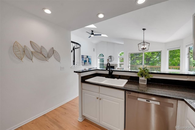 8884 Miners St, Highlands Ranch, CO 80126 - kitchen with stainless steel dishwasher, white cabinets, light wood-style floors, lofted ceiling, and pendant lighting