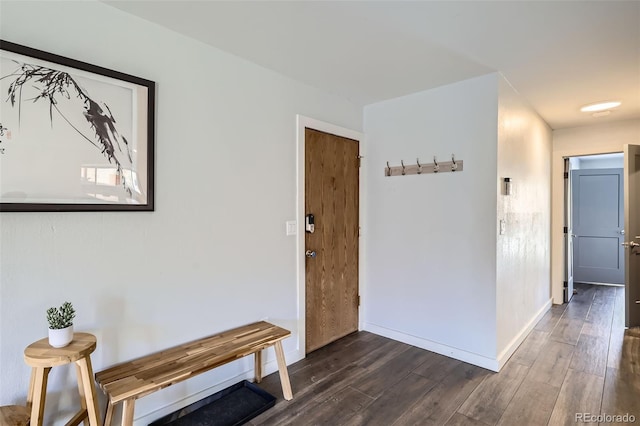 corridor featuring baseboards and dark wood-style flooring