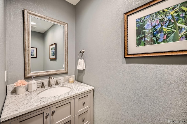 bathroom with vanity and a textured wall