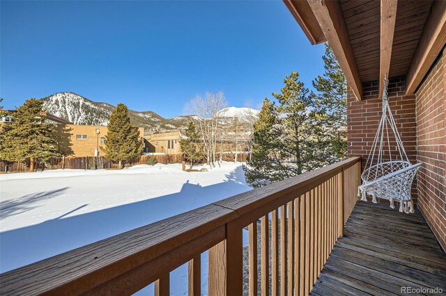 snow covered back of property featuring a mountain view