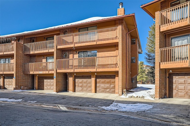 snow covered building with community garages