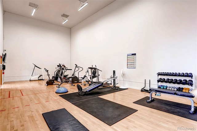 workout area featuring wood finished floors and baseboards