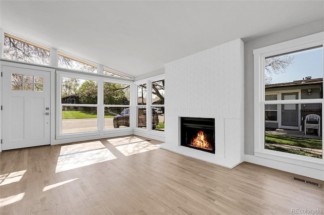 5373 S Prescott St, Littleton, CO 80120 - unfurnished living room with a brick fireplace, wood finished floors, and lofted ceiling