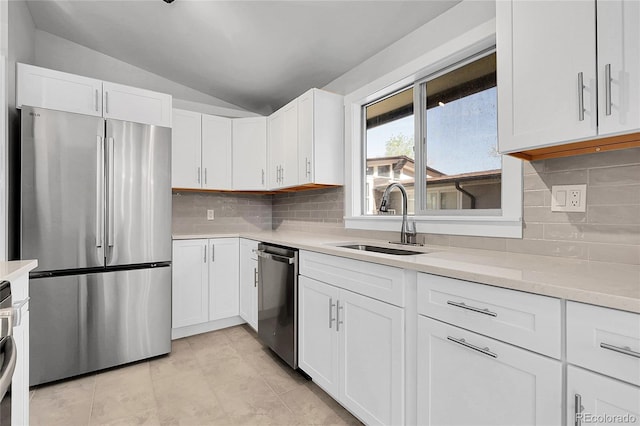 5373 S Prescott St, Littleton, CO 80120 - kitchen featuring appliances with stainless steel finishes, a sink, vaulted ceiling, light countertops, and white cabinetry