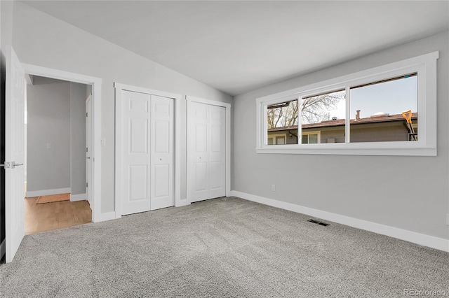 5373 S Prescott St, Littleton, CO 80120 - unfurnished bedroom featuring multiple closets, lofted ceiling, carpet floors, and baseboards