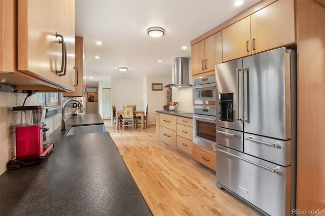 13365 Meadow Glen Ln, Colorado Springs, CO 80908 - kitchen with appliances with stainless steel finishes, island range hood, dark countertops, light wood-style floors, and recessed lighting