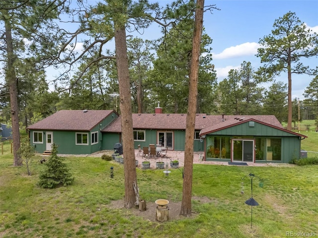 13365 Meadow Glen Ln, Colorado Springs, CO 80908 - rear view of property with a patio area, a yard, board and batten siding, and a chimney