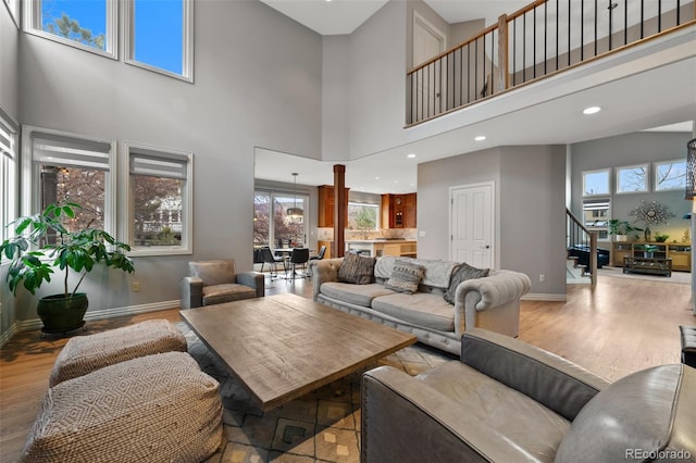 living room with a towering ceiling and light hardwood / wood-style floors