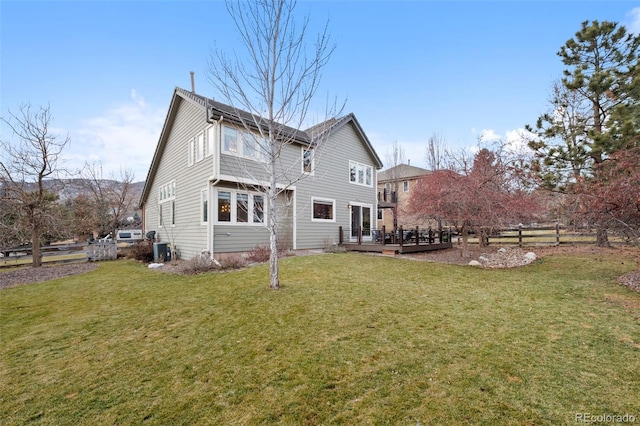 rear view of house with a yard and a wooden deck