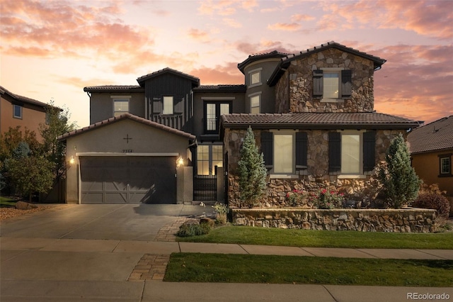 mediterranean / spanish-style home featuring a garage and a lawn