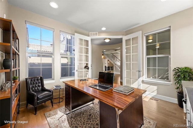 office space with light hardwood / wood-style flooring and french doors